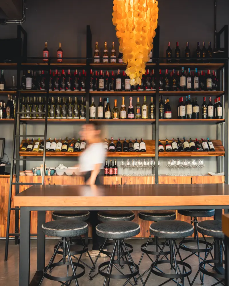 Barra de madera y estantería de la cava de vinos de Casa Obrador en el Parkway, Bogotá
